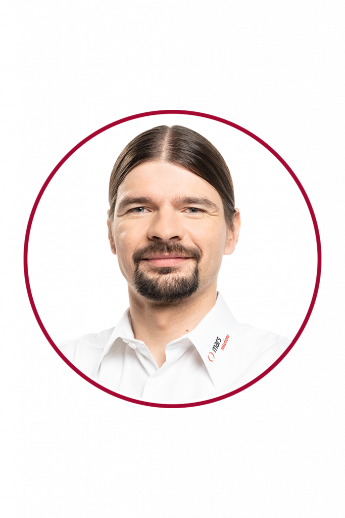 Porträt von Ralf Schwarzmaier, Geschäftsführer von Mars Solutions, im weißen Hemd mit Firmenlogo, vor weißem Hintergrund in rundem Rahmen.