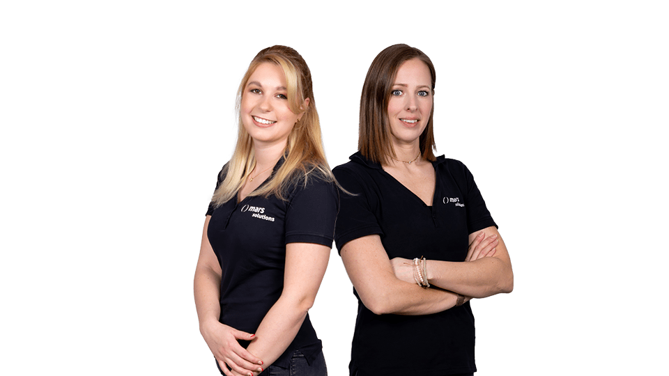 Zwei Frauen stehen nebeneinander in schwarzen Polohemden mit einem neutralen Hintergrund.